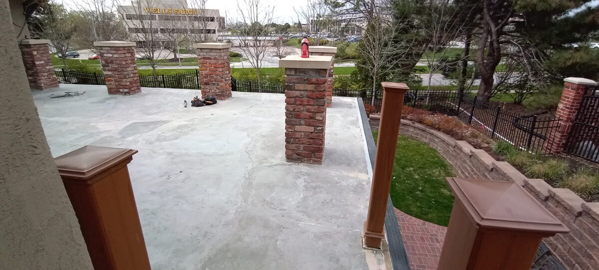 Resurfaced concrete patio with brick pillars in Omaha after restoration