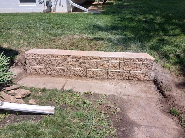 New block retaining wall with freshly regraded lawn