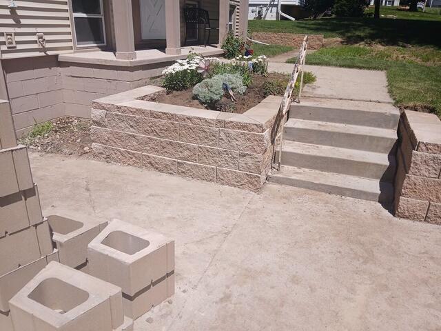 Finished planter walls and steps with railing at a home entry