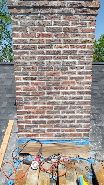 Rebuilt brick chimney with fresh mortar joints on an Omaha roof