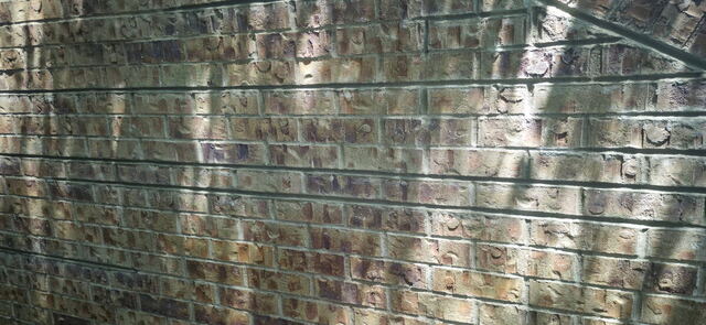 Antique glazed brick wall with repointed mortar joints in Omaha