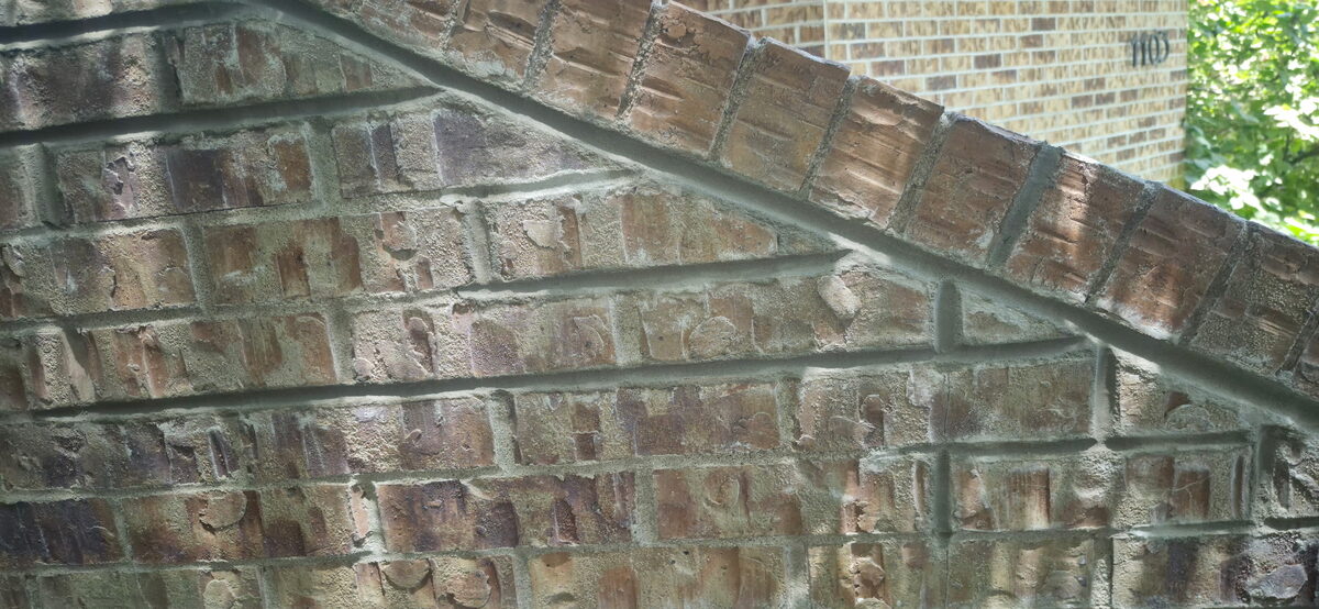 Antique glazed brick wall with fresh color-matched mortar joints after tuckpointing in Omaha