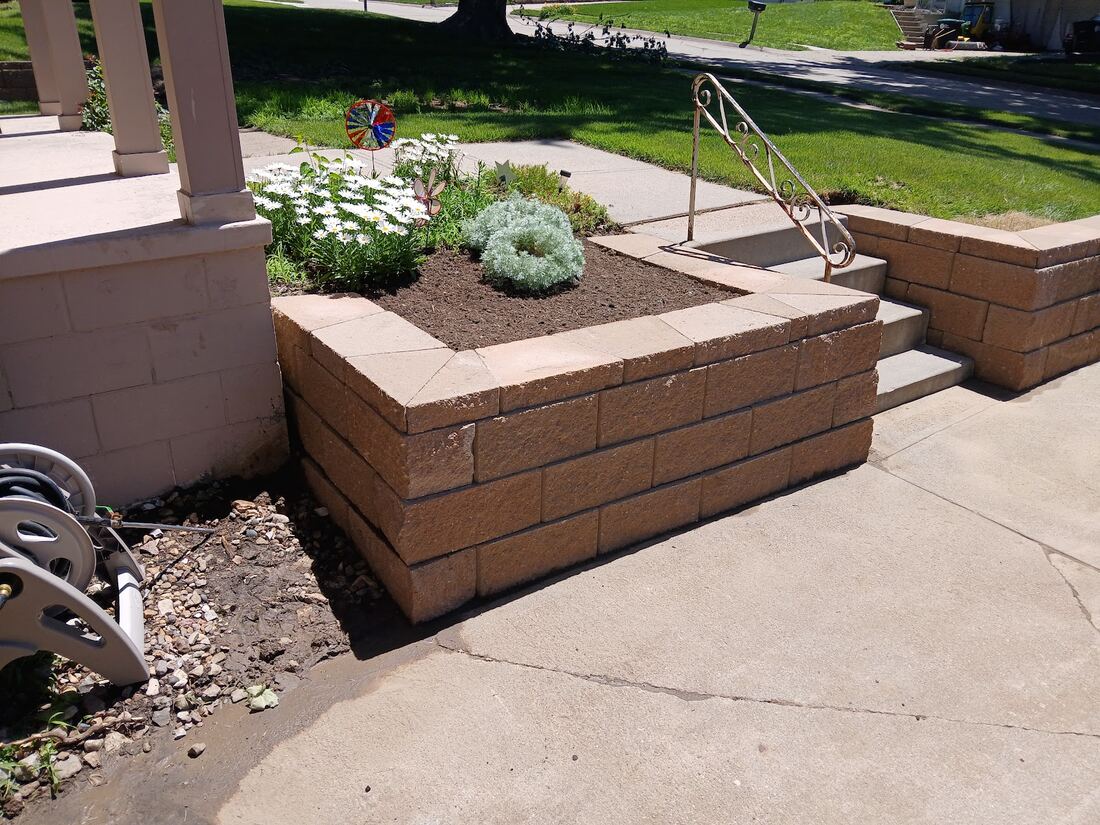Block masonry planter boxes built beside a front porch in Omaha
